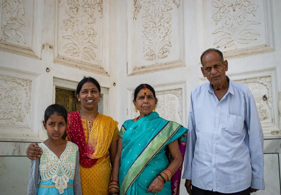Three generations of a family standing together at home